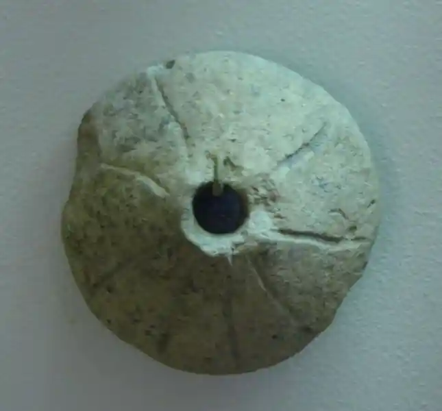 Nine-pointed cross on a clay with hole in the center